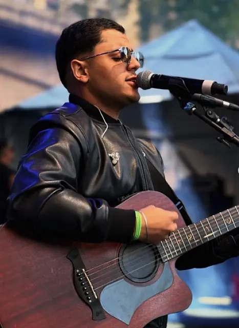 Artista sobe ao palco e anima público durante evento cultural